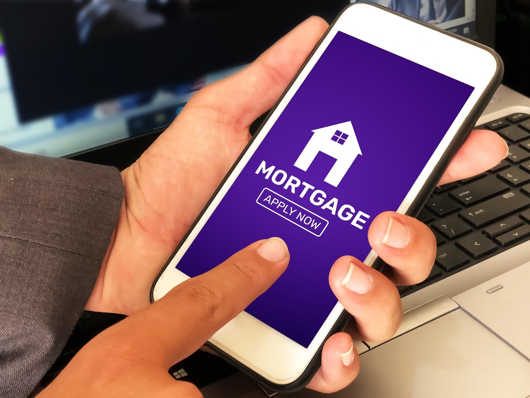 Applying For a Mortgage Through Smartphone With Laptop